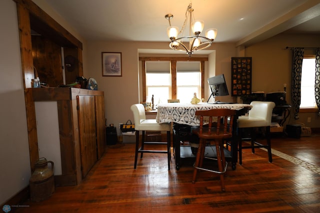 dining area with hardwood / wood-style flooring and an inviting chandelier