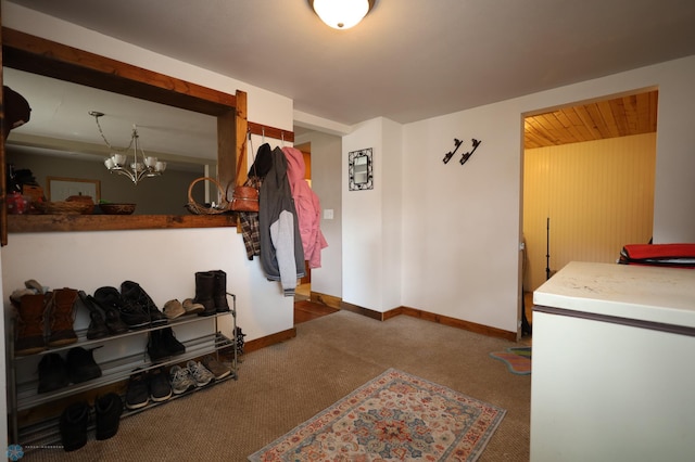 interior space with baseboards, carpet floors, and a chandelier