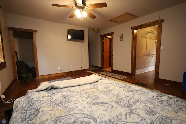 bedroom featuring attic access, baseboards, and wood finished floors