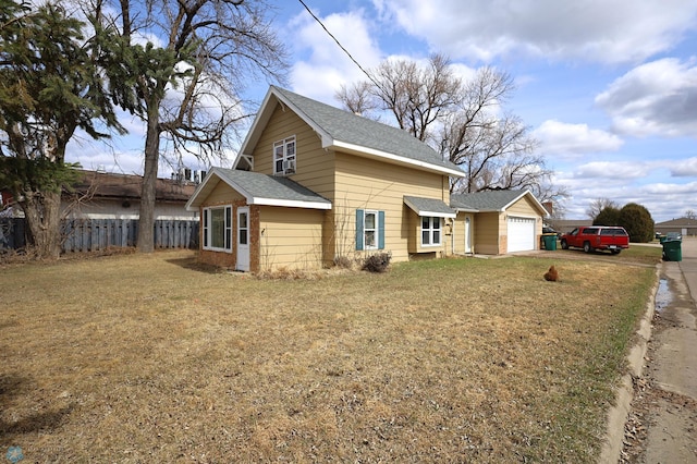 view of property exterior featuring a yard, roof with shingles, and fence