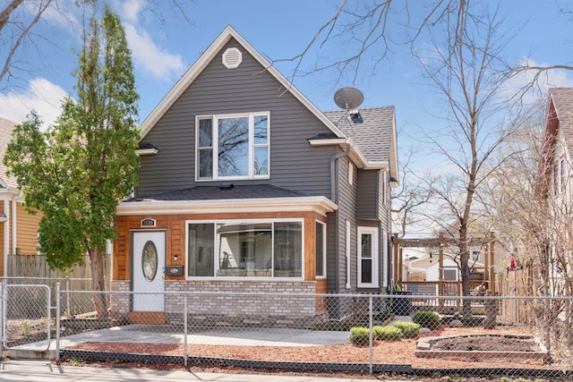 view of front of property featuring roof with shingles and a fenced front yard