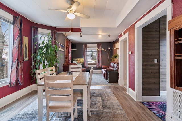dining area with a healthy amount of sunlight, a ceiling fan, and wood finished floors