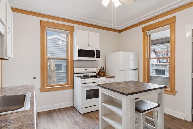 kitchen featuring white appliances, wooden counters, white cabinetry, light wood-type flooring, and visible vents