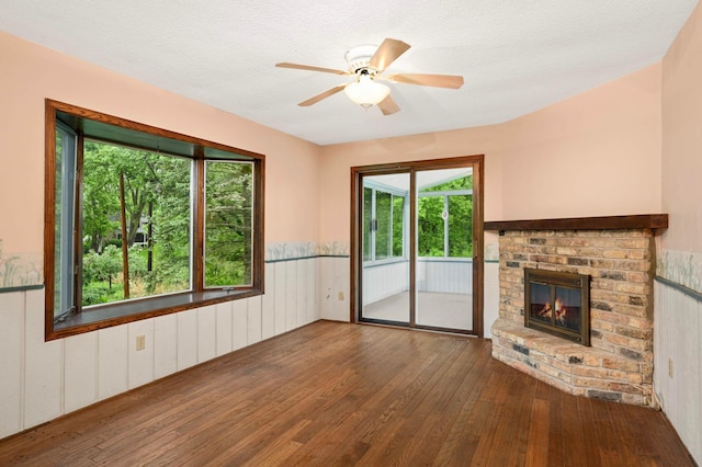 5410 Creek View Ln, Edina, MN 55439 - unfurnished living room with hardwood / wood-style floors, plenty of natural light, a brick fireplace, and wooden walls