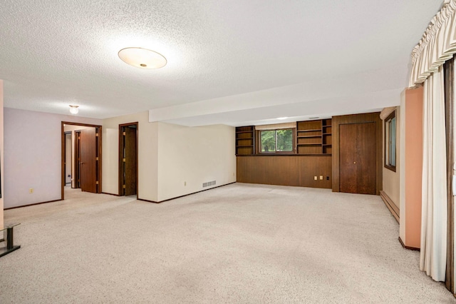 5410 Creek View Ln, Edina, MN 55439 - spare room featuring light colored carpet, a textured ceiling, and wood walls