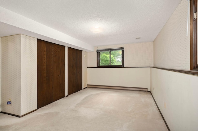 5410 Creek View Ln, Edina, MN 55439 - unfurnished bedroom featuring a baseboard heating unit, a textured ceiling, light colored carpet, wallpapered walls, and baseboards