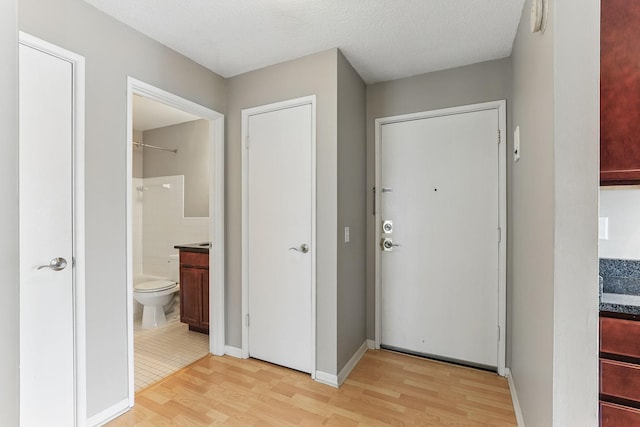 entrance foyer with light wood-style flooring and a textured ceiling
