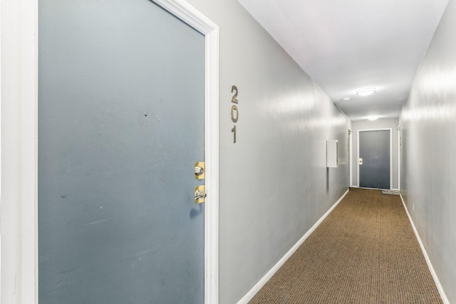 corridor with baseboards and carpet floors