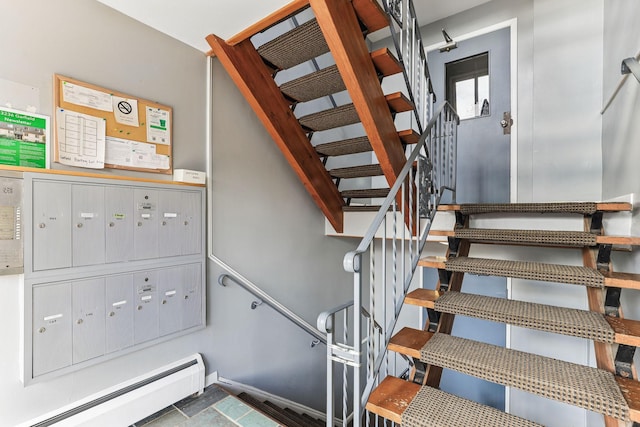 stairs featuring a baseboard radiator, baseboards, and mail area