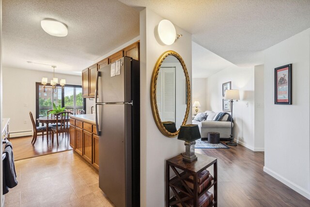 6615 Lake Shore Dr S Unit 601, Richfield, MN 55423 - hall with a chandelier, a textured ceiling, light wood finished floors, and baseboards