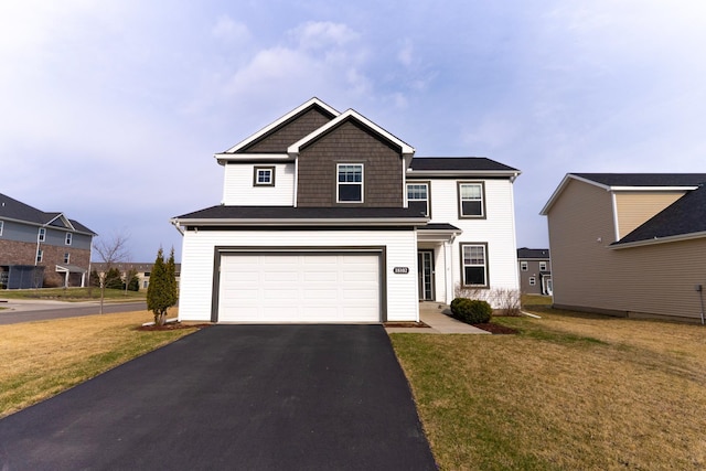 traditional-style home featuring a front lawn, driveway, and a garage
