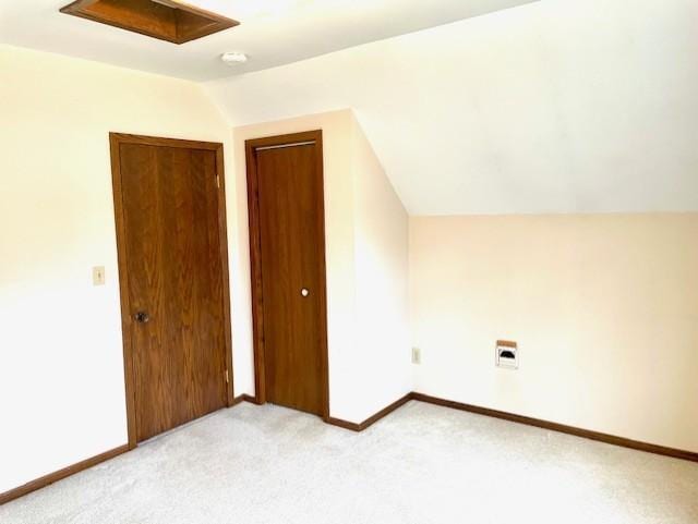 additional living space with baseboards, light carpet, and lofted ceiling