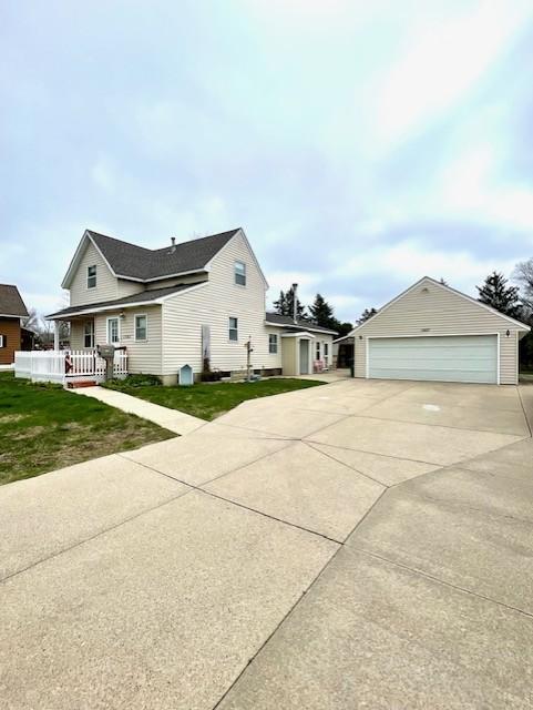 view of front of home featuring a detached garage and a front lawn