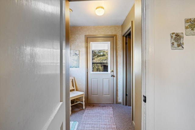 doorway to outside featuring carpet flooring