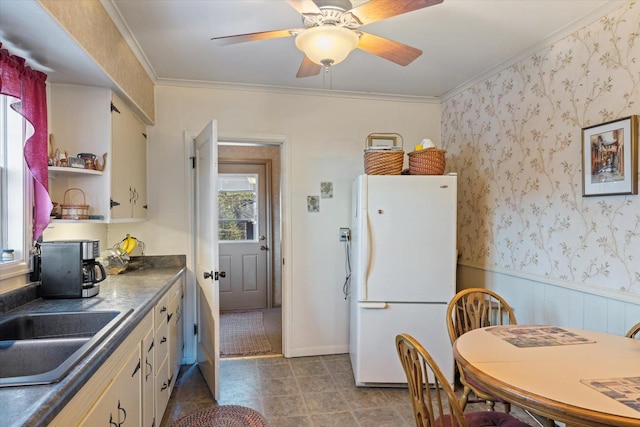 kitchen featuring open shelves, a sink, ceiling fan, ornamental molding, and freestanding refrigerator