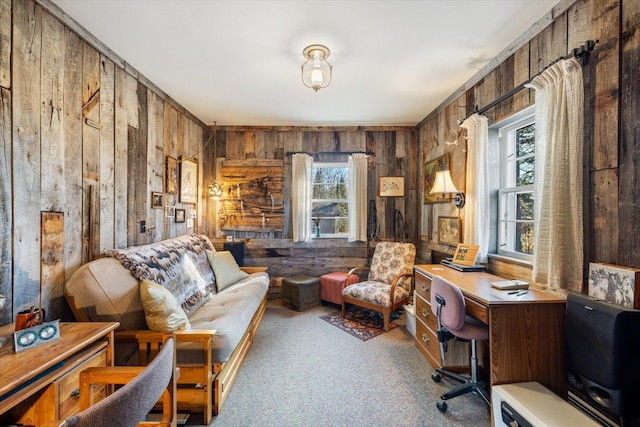 sitting room featuring wooden walls and carpet floors