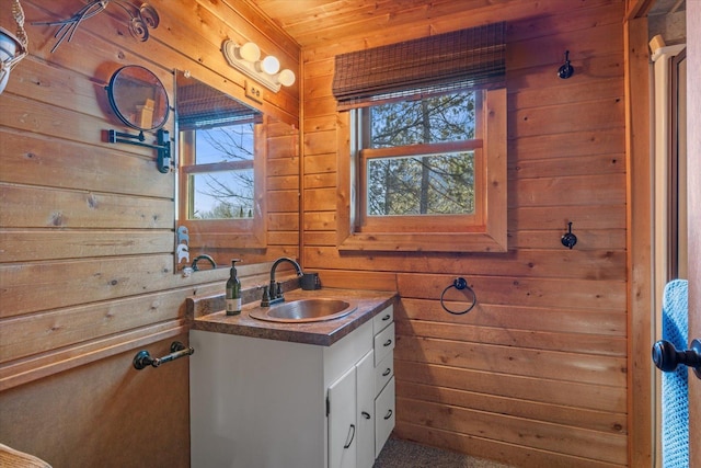 bathroom with plenty of natural light, wooden walls, and vanity