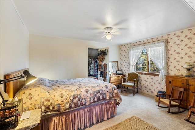 bedroom featuring wallpapered walls, a ceiling fan, a closet, and light colored carpet