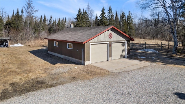 detached garage featuring fence