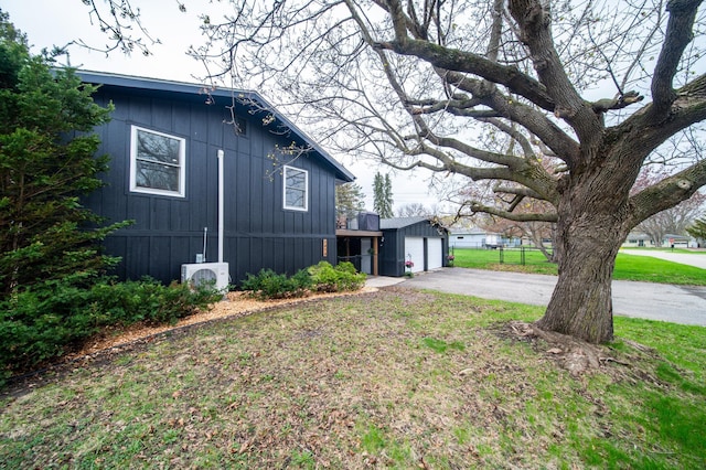 1474 Aldrich Ct, Faribault, MN 55021 - view of side of property featuring a lawn, driveway, an outbuilding, and a garage