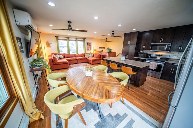 1474 Aldrich Ct, Faribault, MN 55021 - dining space featuring a ceiling fan, a wall unit AC, light wood-style flooring, and recessed lighting