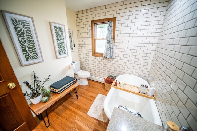 1474 Aldrich Ct, Faribault, MN 55021 - bathroom featuring a tub, tile walls, toilet, and wood finished floors