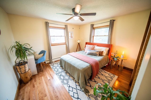 1474 Aldrich Ct, Faribault, MN 55021 - bedroom with a baseboard heating unit, multiple windows, a baseboard radiator, and wood finished floors