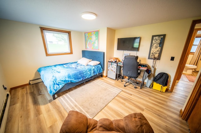 1474 Aldrich Ct, Faribault, MN 55021 - bedroom featuring wood finished floors, baseboards, baseboard heating, and a baseboard heating unit