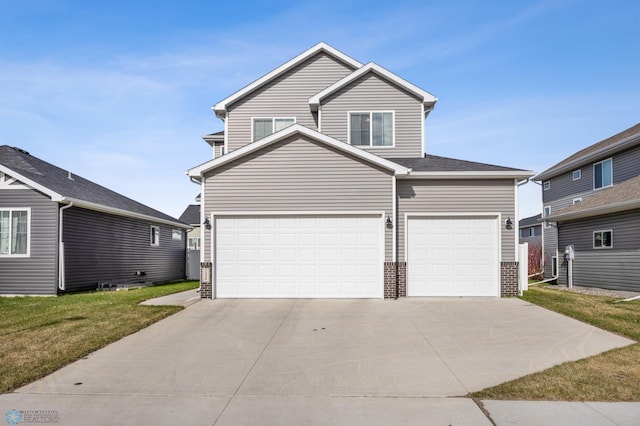 traditional-style house with a garage, brick siding, a front lawn, and driveway