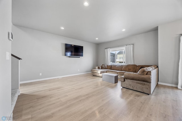 living area featuring baseboards, recessed lighting, and light wood-style floors