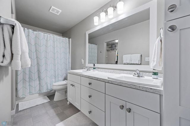 full bath featuring visible vents, toilet, double vanity, and a sink
