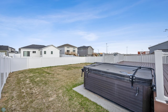 view of yard featuring a deck, fence private yard, a residential view, and a hot tub