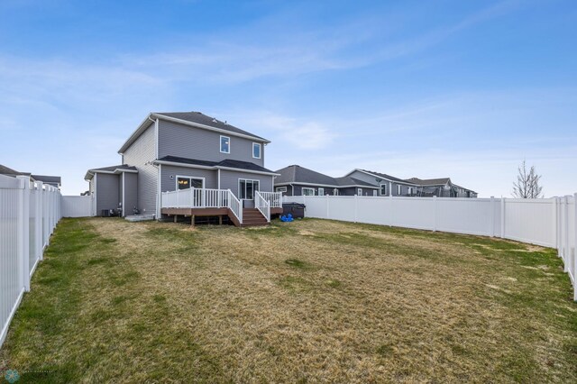 back of house with a lawn, a deck, and a fenced backyard
