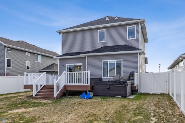back of property featuring a deck, a fenced backyard, a gate, and a hot tub