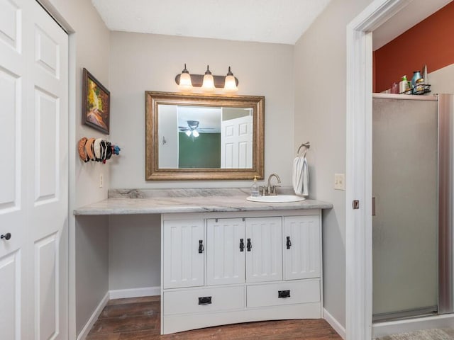 4001 Heritage Hills Dr Unit 105, Bloomington, MN 55437 - bathroom featuring wood finished floors, vanity, baseboards, a stall shower, and ceiling fan