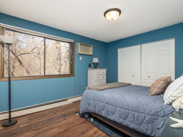 4001 Heritage Hills Dr Unit 105, Bloomington, MN 55437 - bedroom featuring baseboard heating, wood finished floors, a textured ceiling, a closet, and a wall unit AC