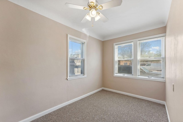 spare room featuring baseboards, carpet flooring, and a ceiling fan