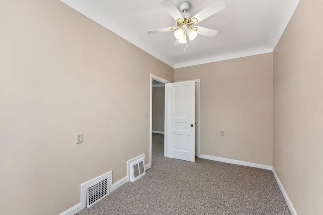 carpeted spare room featuring ceiling fan and baseboards