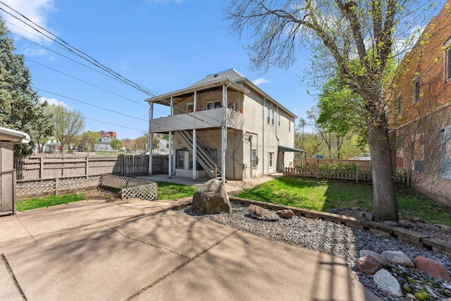 rear view of property featuring a patio area, stucco siding, and a balcony