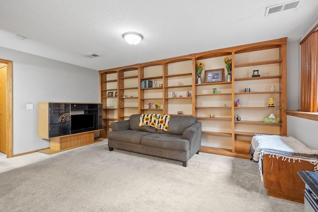 living area featuring carpet flooring, a textured ceiling, and visible vents