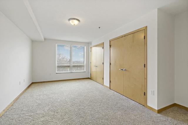 1502 5th St N Unit 401, Hopkins, MN 55305 - unfurnished bedroom with carpet floors, baseboards, and multiple closets