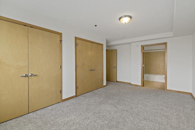 1502 5th St N Unit 401, Hopkins, MN 55305 - unfurnished bedroom with two closets, baseboards, light carpet, and connected bathroom