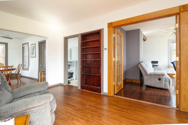 living area with wood finished floors, a wealth of natural light, and ceiling fan