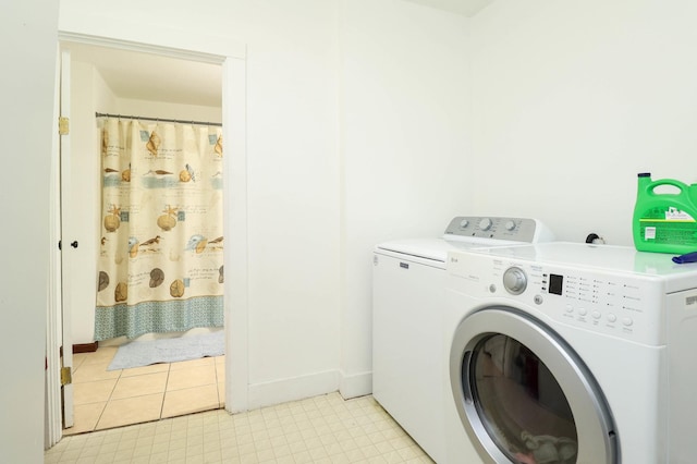laundry area with light floors, baseboards, washer and dryer, and laundry area