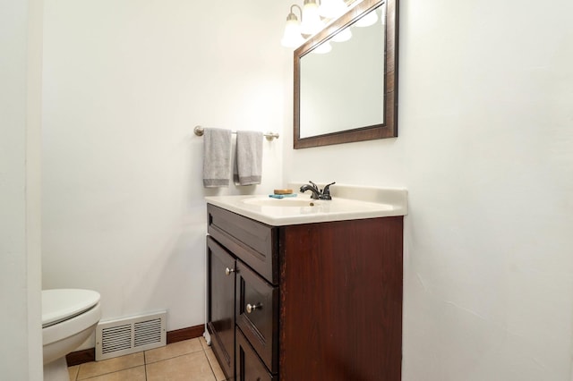half bathroom featuring tile patterned flooring, visible vents, toilet, and vanity