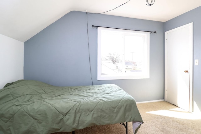 bedroom with vaulted ceiling, carpet floors, and baseboards