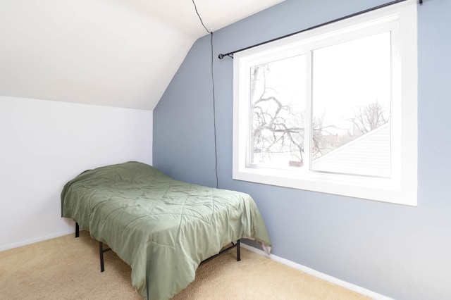carpeted bedroom featuring lofted ceiling and baseboards