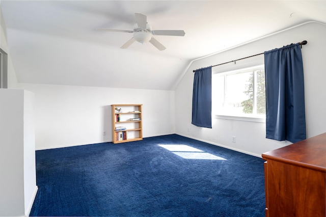 additional living space featuring dark carpet, vaulted ceiling, baseboards, and ceiling fan