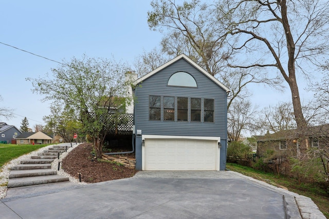 view of front facade with stairway, an attached garage, driveway, and a chimney