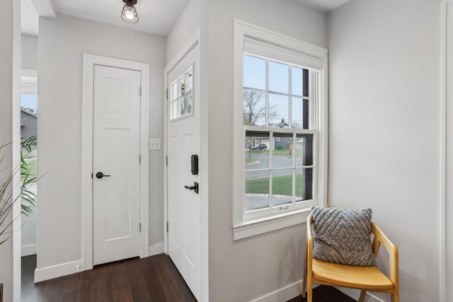 foyer with baseboards and dark wood-style floors